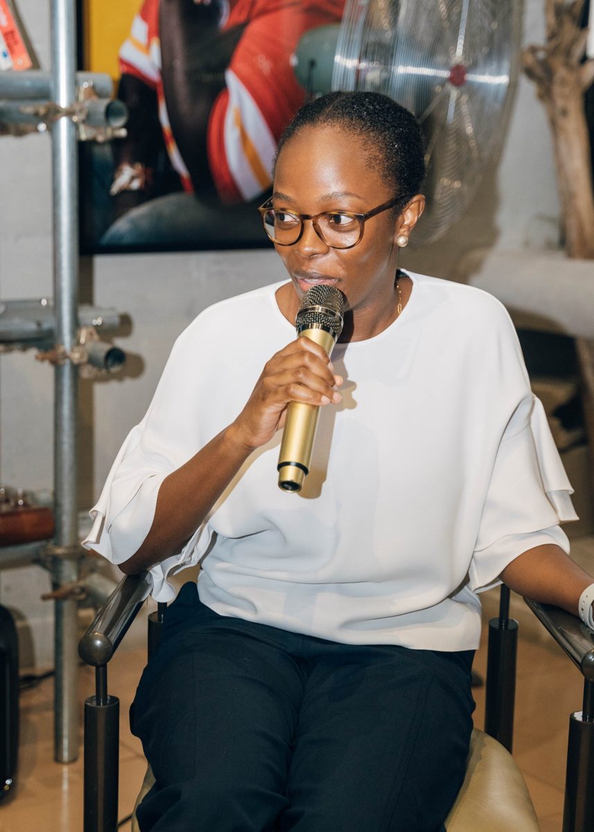 Folayemi Agusto speaking into a microphone on a panel